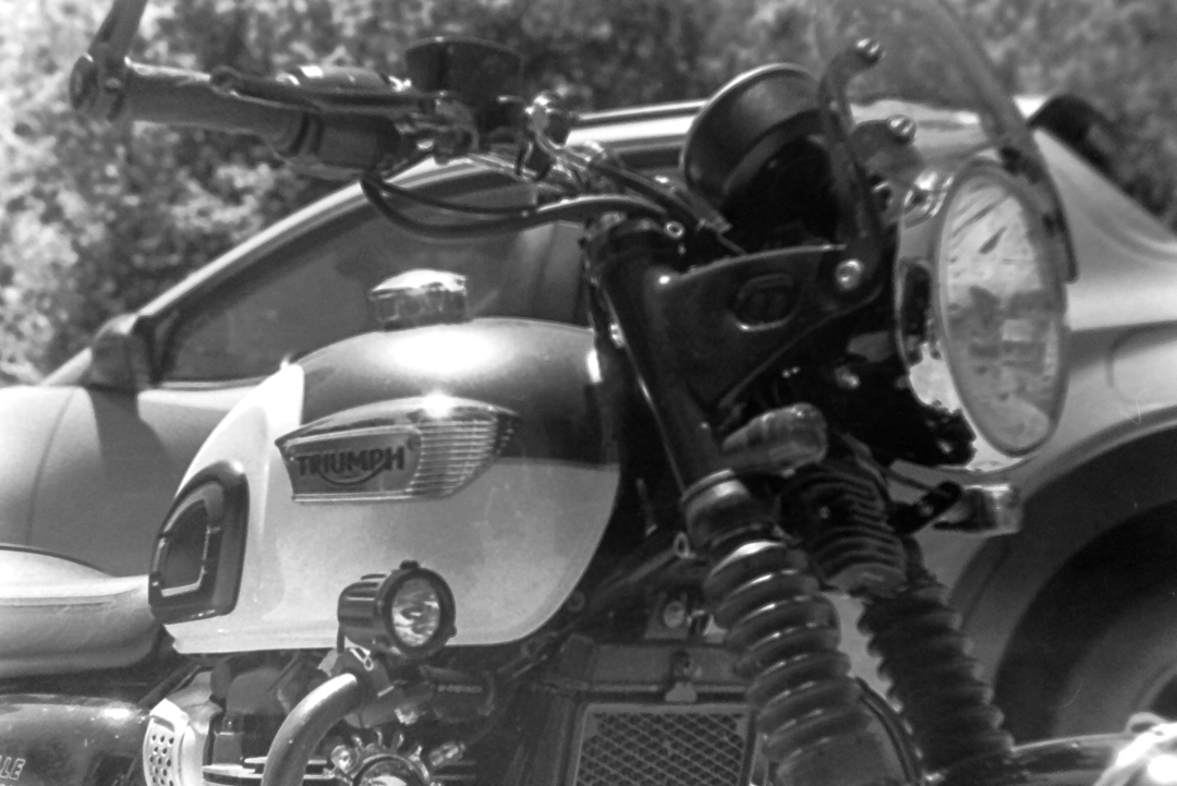 a close up of my Triumph motorcycle with my Hyundai Santa Cruz in the background.